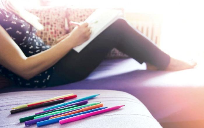 Relaxed lady with pencils and coloring page